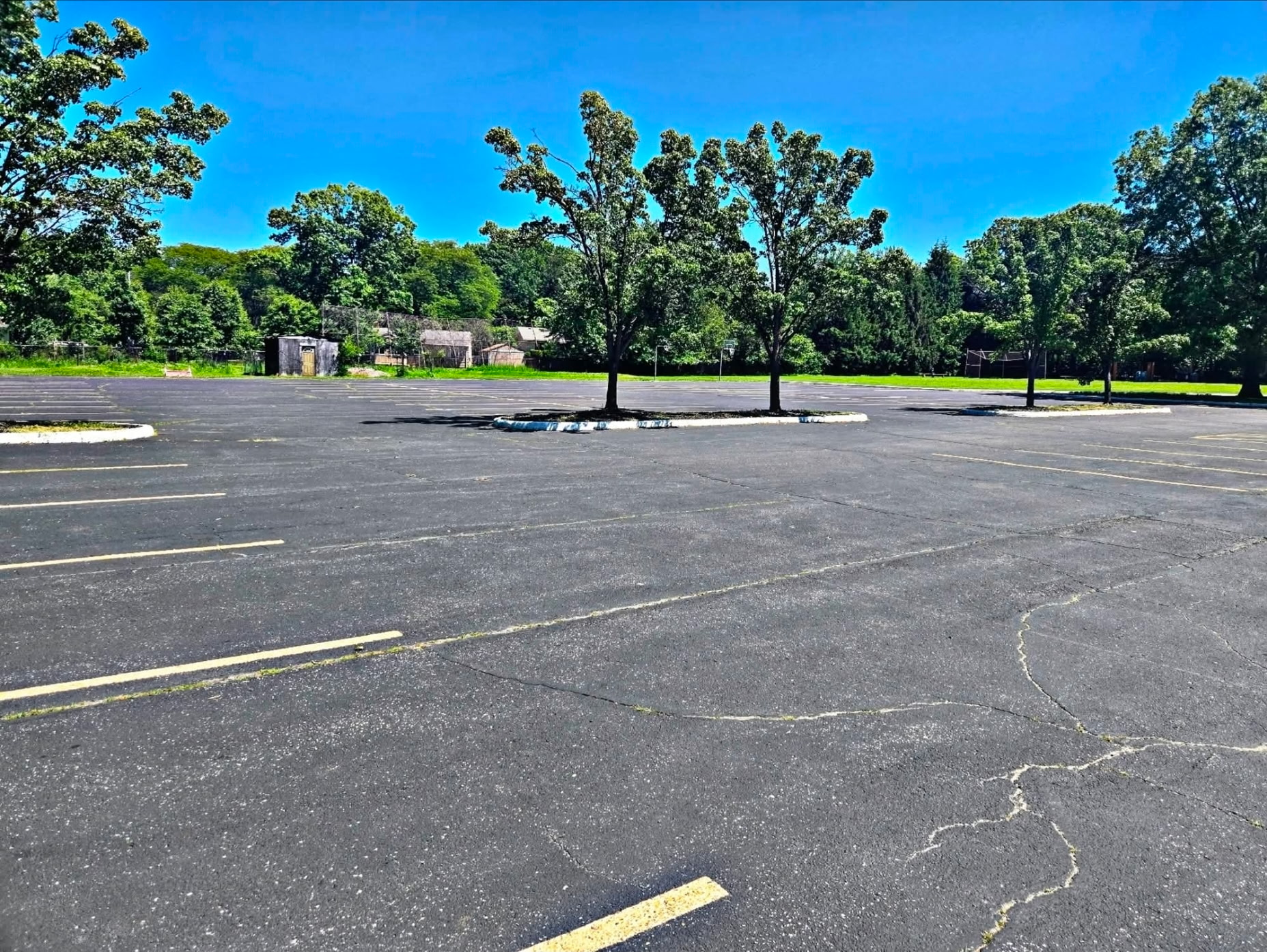 Large open parking lot behind the church with shade trees